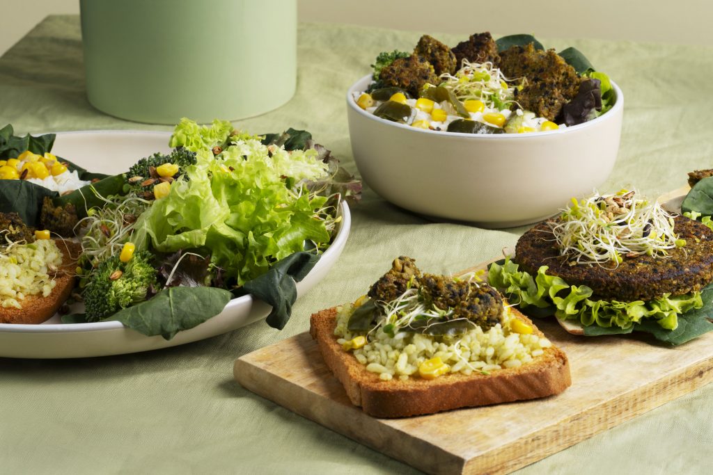 Divers plats végétariens verts, colorés et appétissants, présentés sur une table.