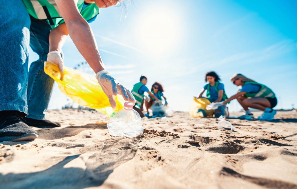Des collaborateurs travaillant ensemble pour nettoyer les déchets éparpillés sur une plage.