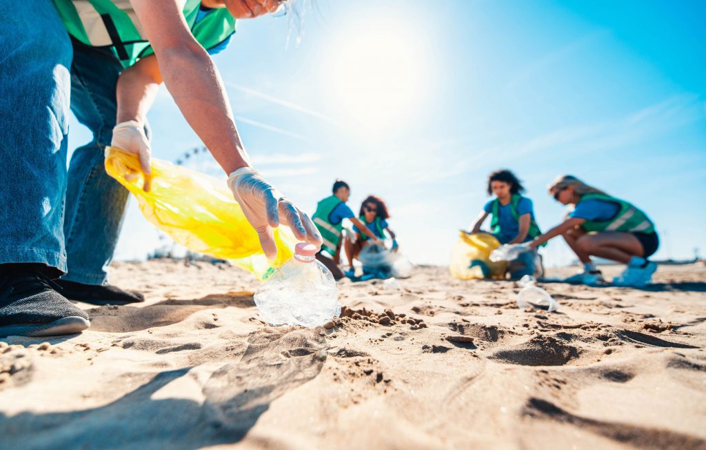 Des collaborateurs travaillant ensemble pour nettoyer les déchets éparpillés sur une plage.