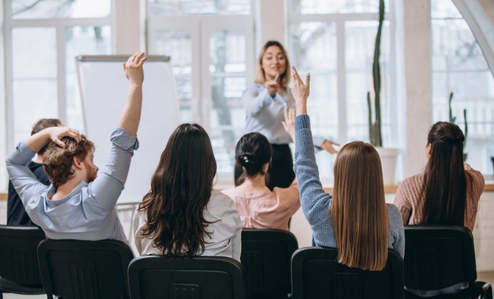 female-speaker-giving-presentation-hall-university-workshop-audience-conference-hall (1)